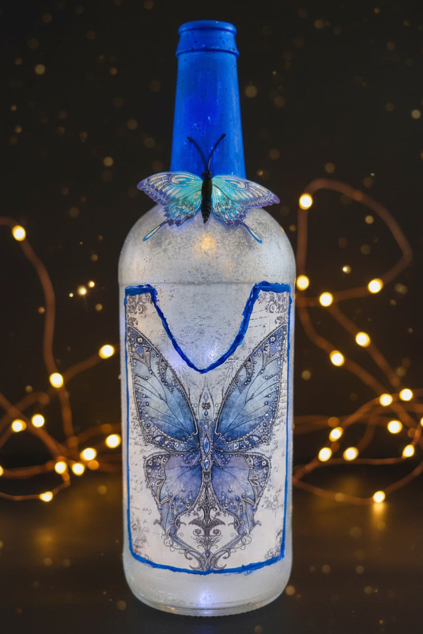Blue lighted decorative glass bottle with butterfly pattern and blue cap